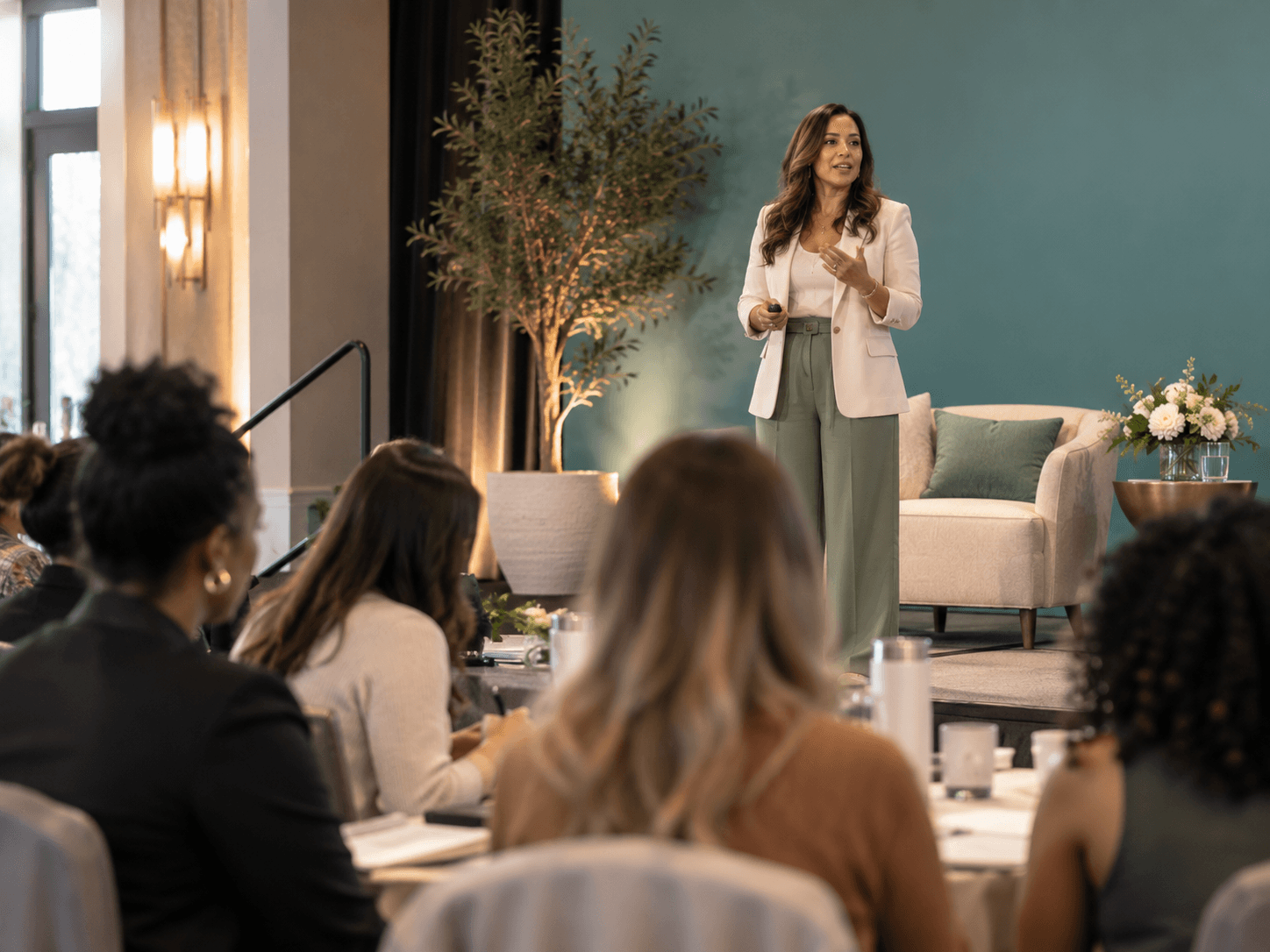 A woman presenting on stage to an attentive audience